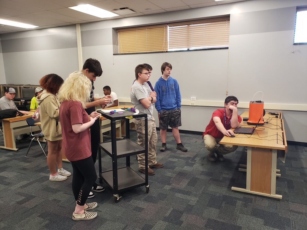 High School students gathered around a 3D Printer